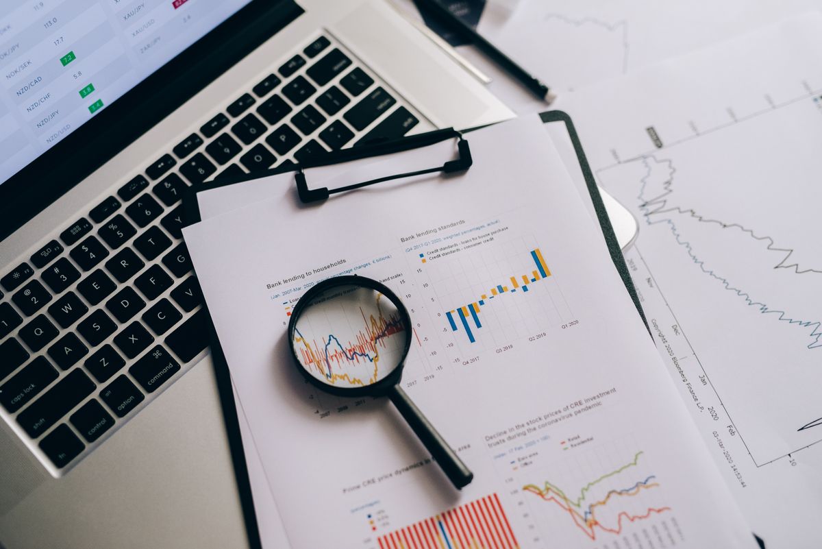 Magnifying glass over data and charts, representing careful research
